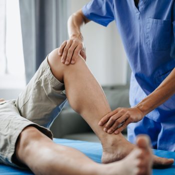 Close up of Physiotherapist working with patient on the bed in clinic