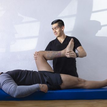 Physiotherapist checking the function of his patient's leg.